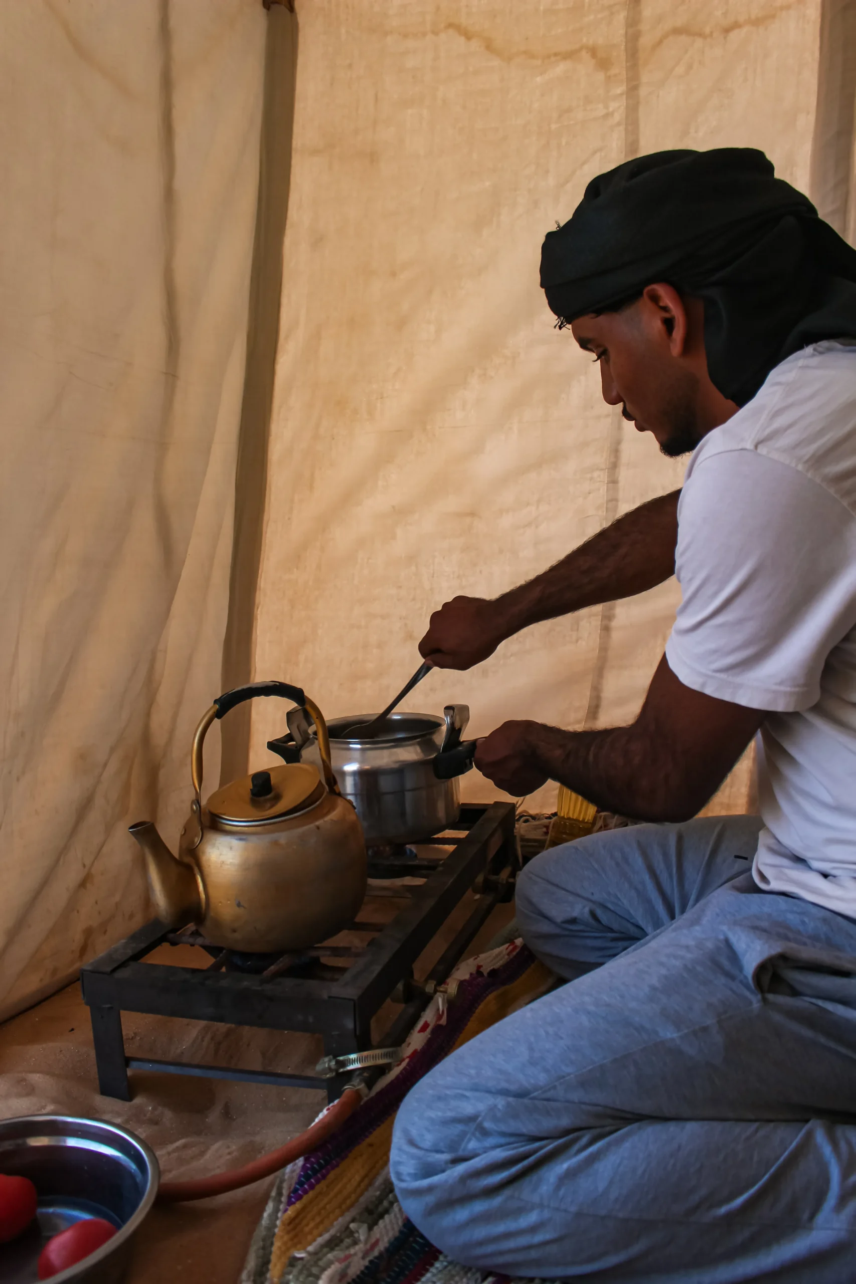 Local guide Eyad Elzaghandi preparing fresh Bedouin tea and food at a real White Desert camp