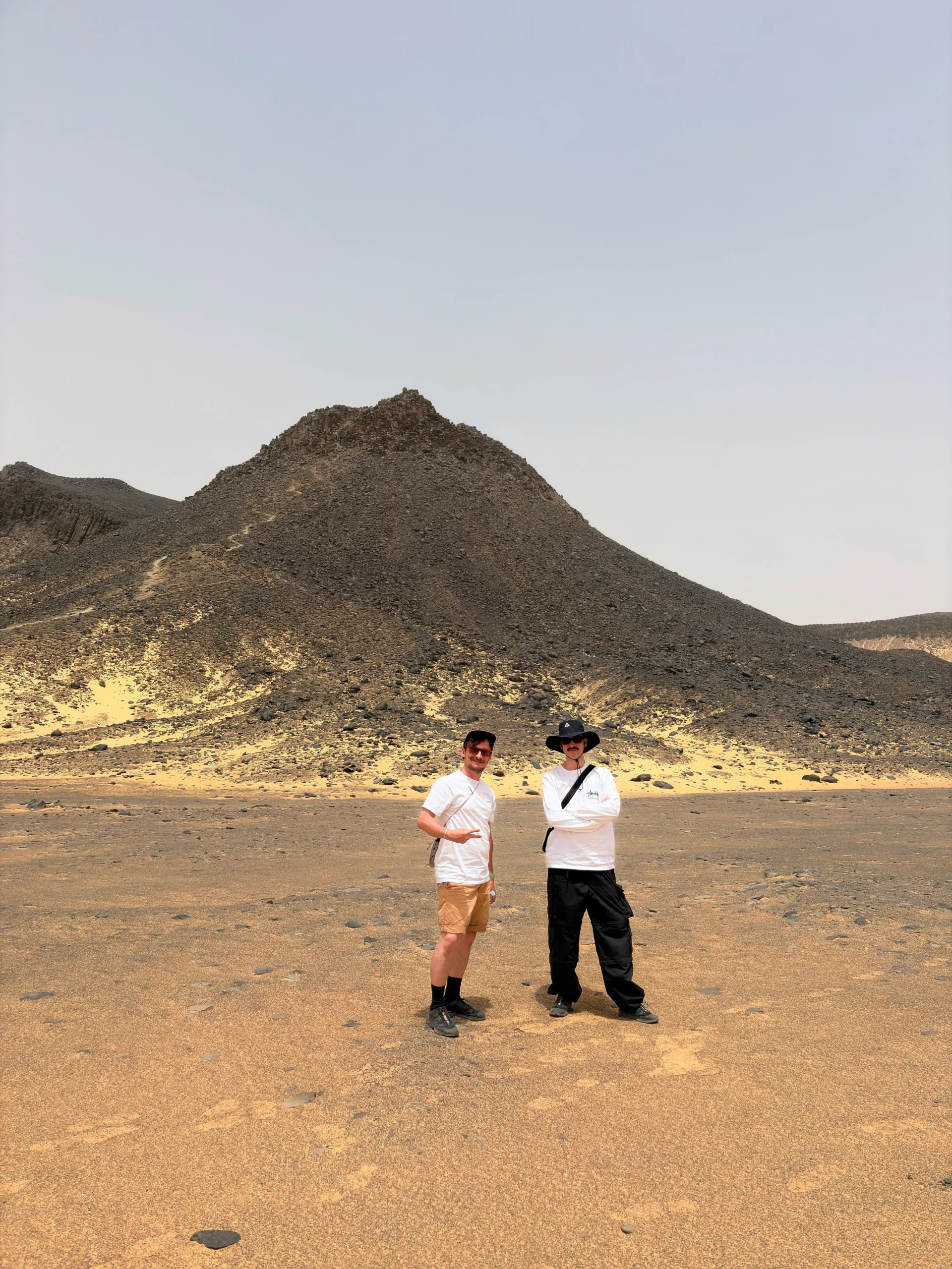 Travelers exploring a volcanic mountain in the Black Desert on the 2027 Bahariya solar eclipse expedition