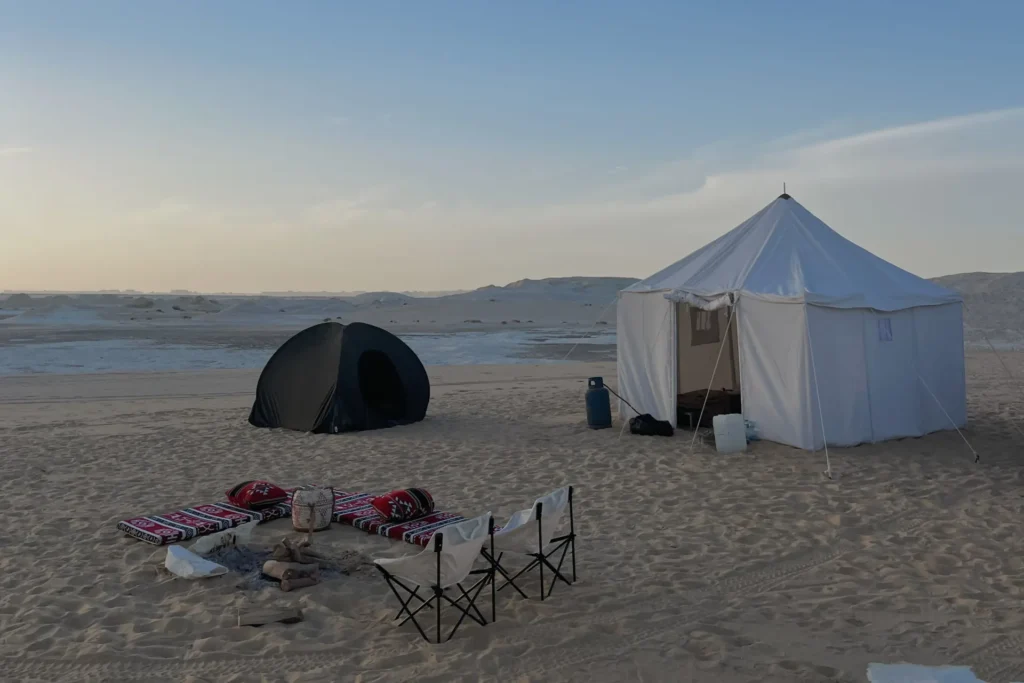 Private white tent, sleeping tent and seating arranged in the White Desert